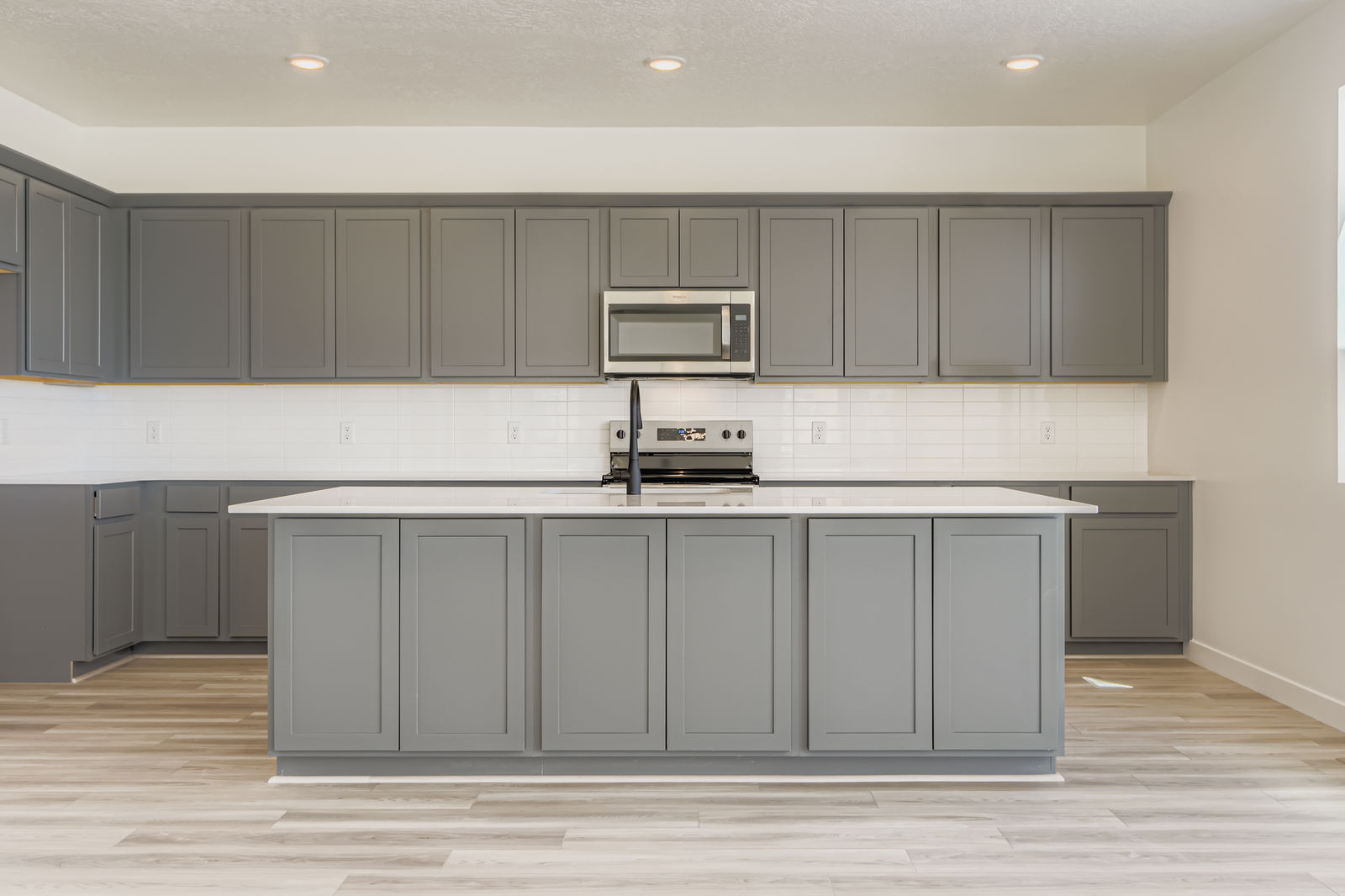 A kitchen with white cabinets.