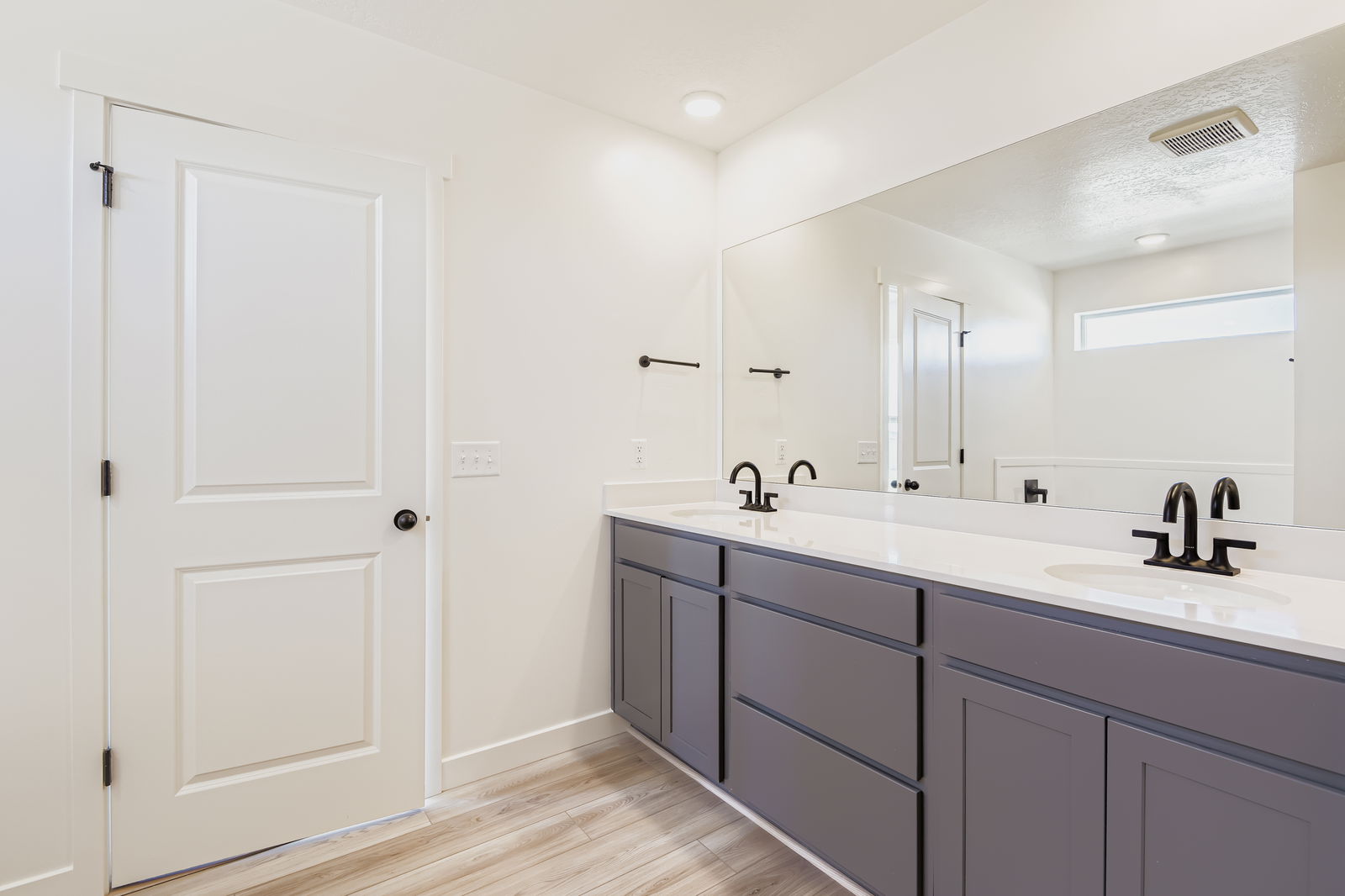 A bathroom with white cabinets.