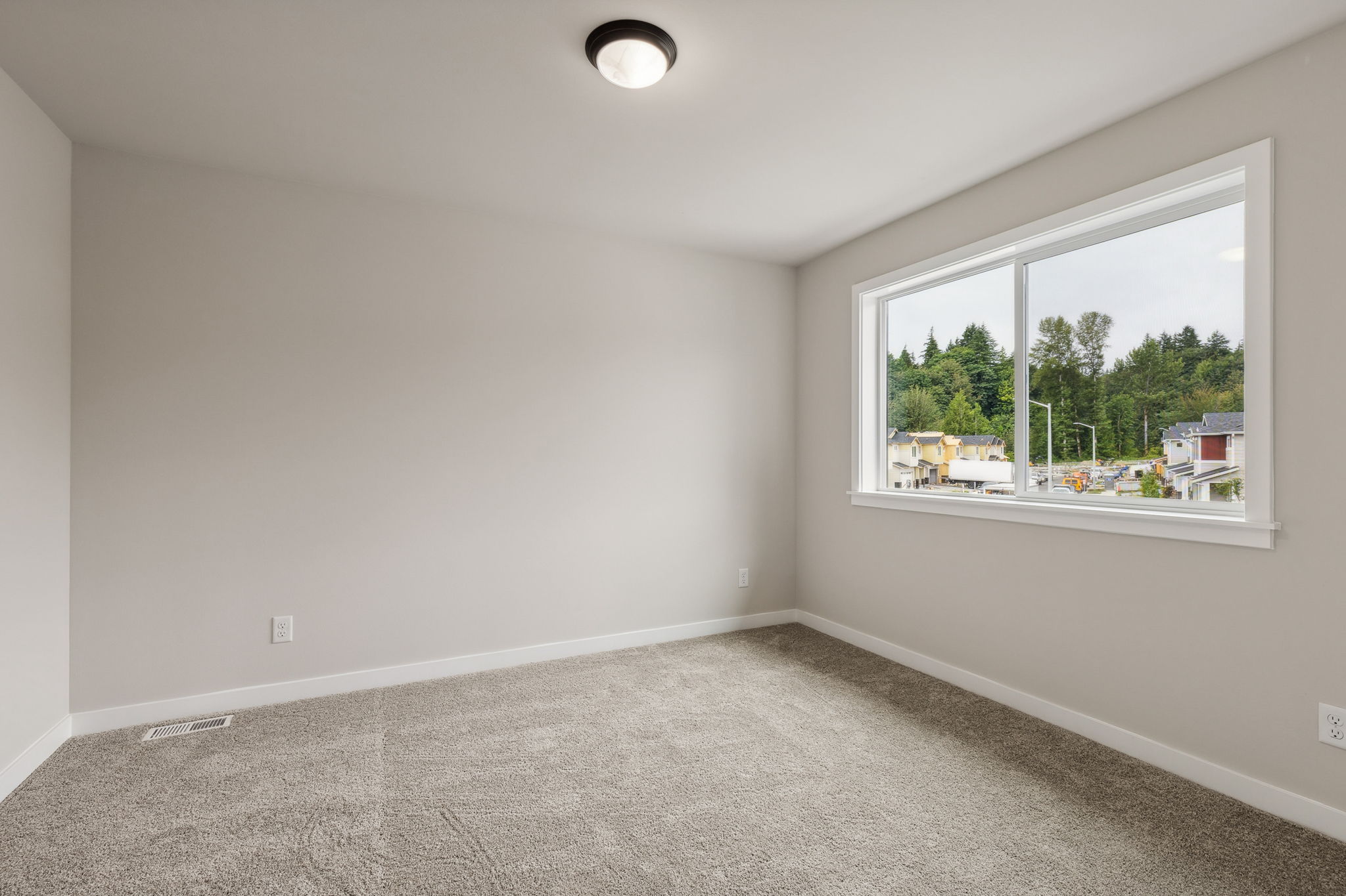 A room with a window and a carpet.