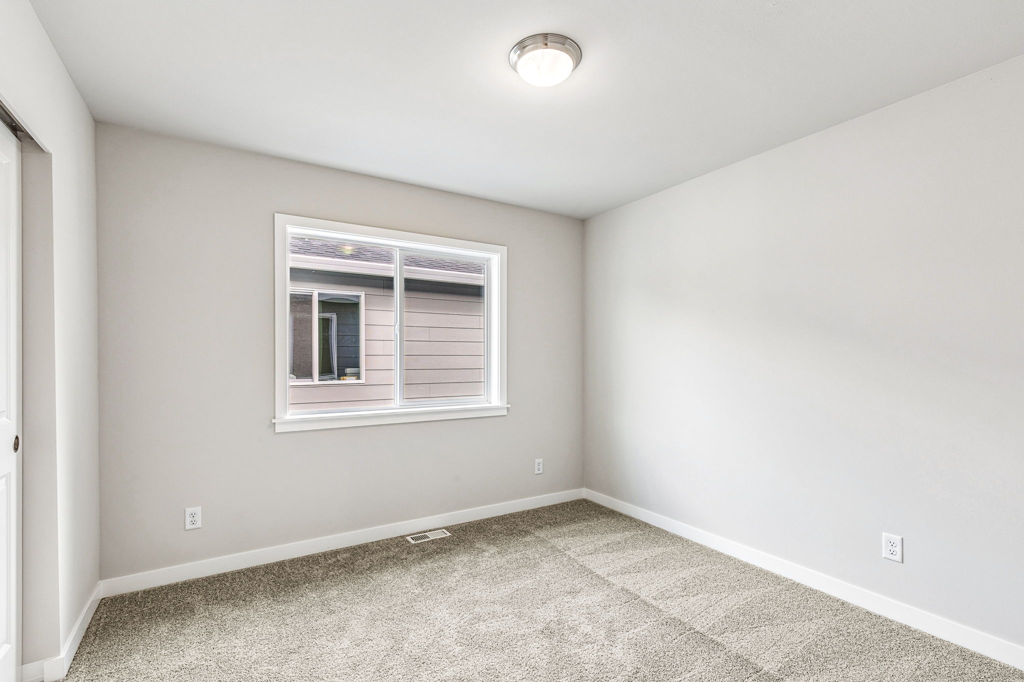 A room with a window and a carpet.