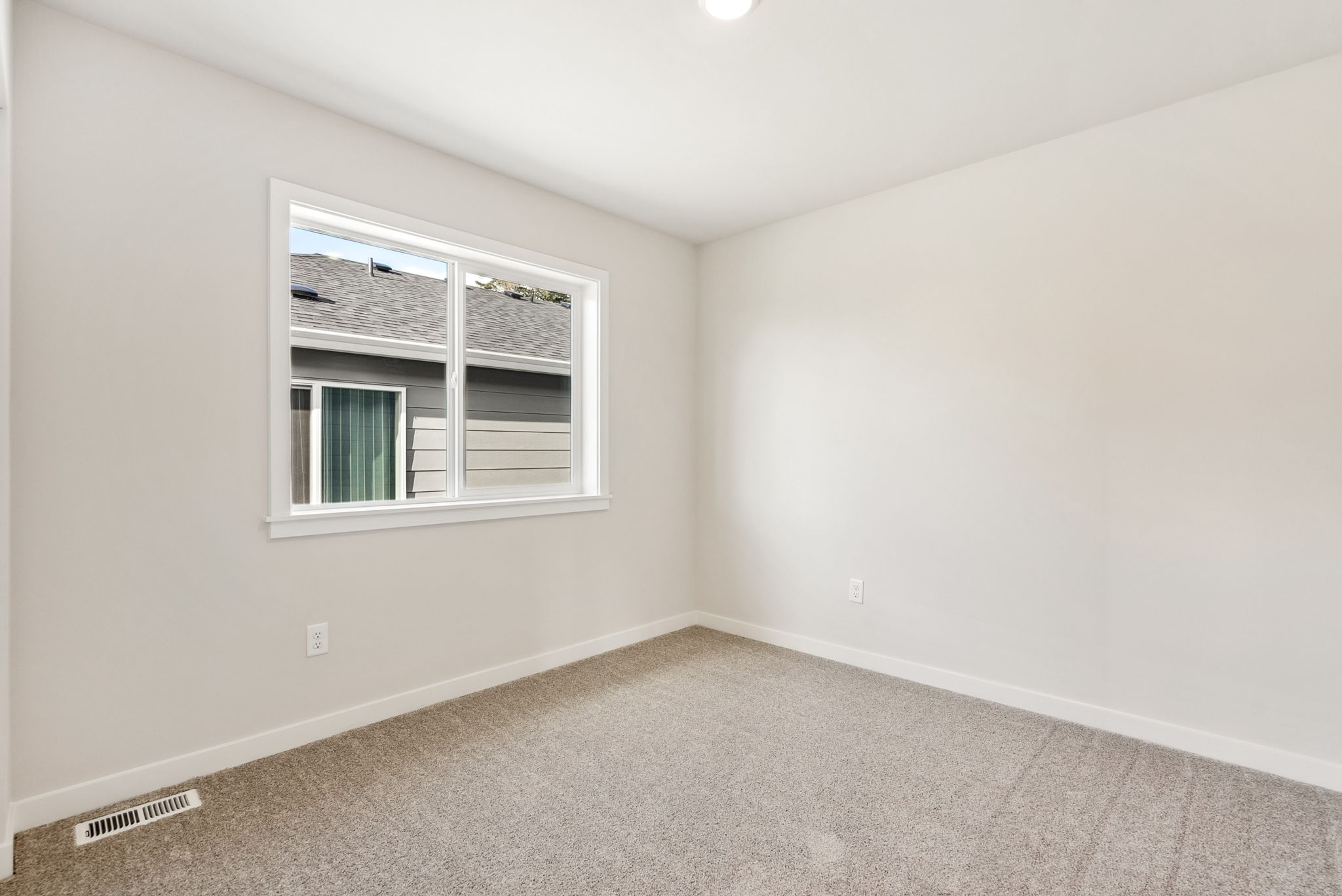 A room with a window and carpet.