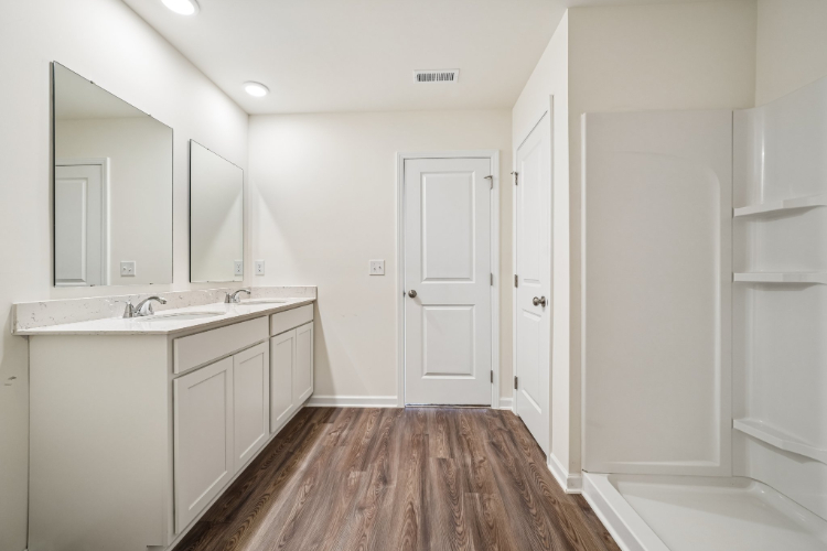 A bathroom with white cabinets.