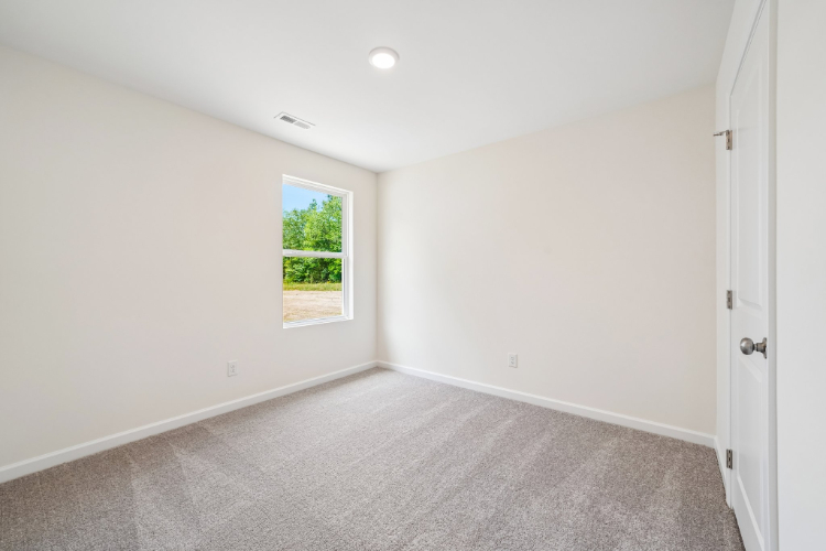 A room with a window and a carpet.