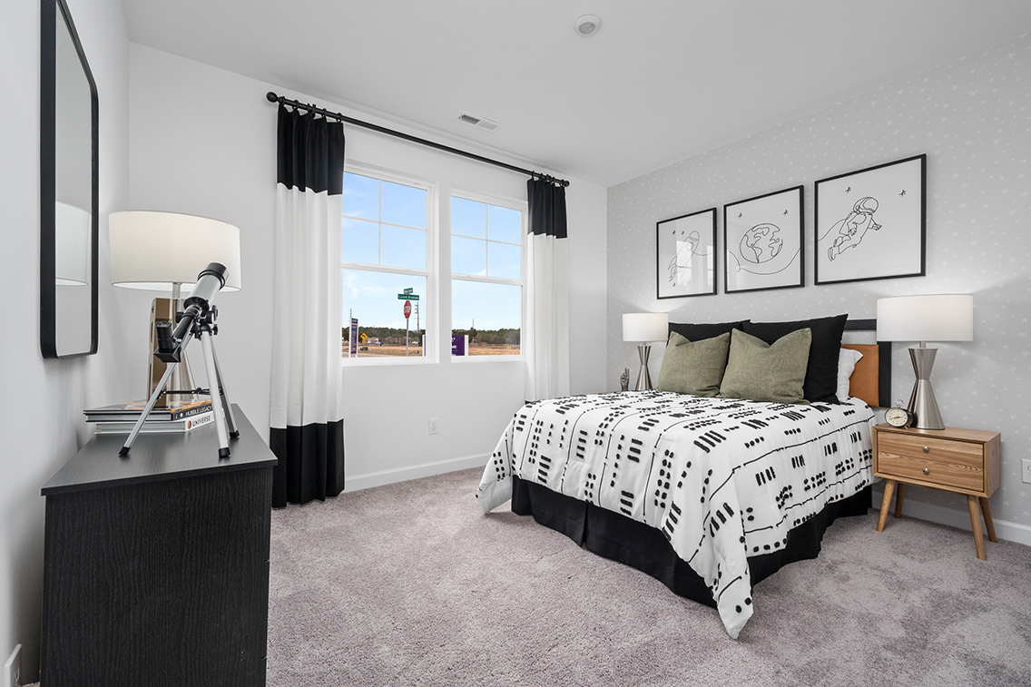 A bedroom with a bed and a lamp.