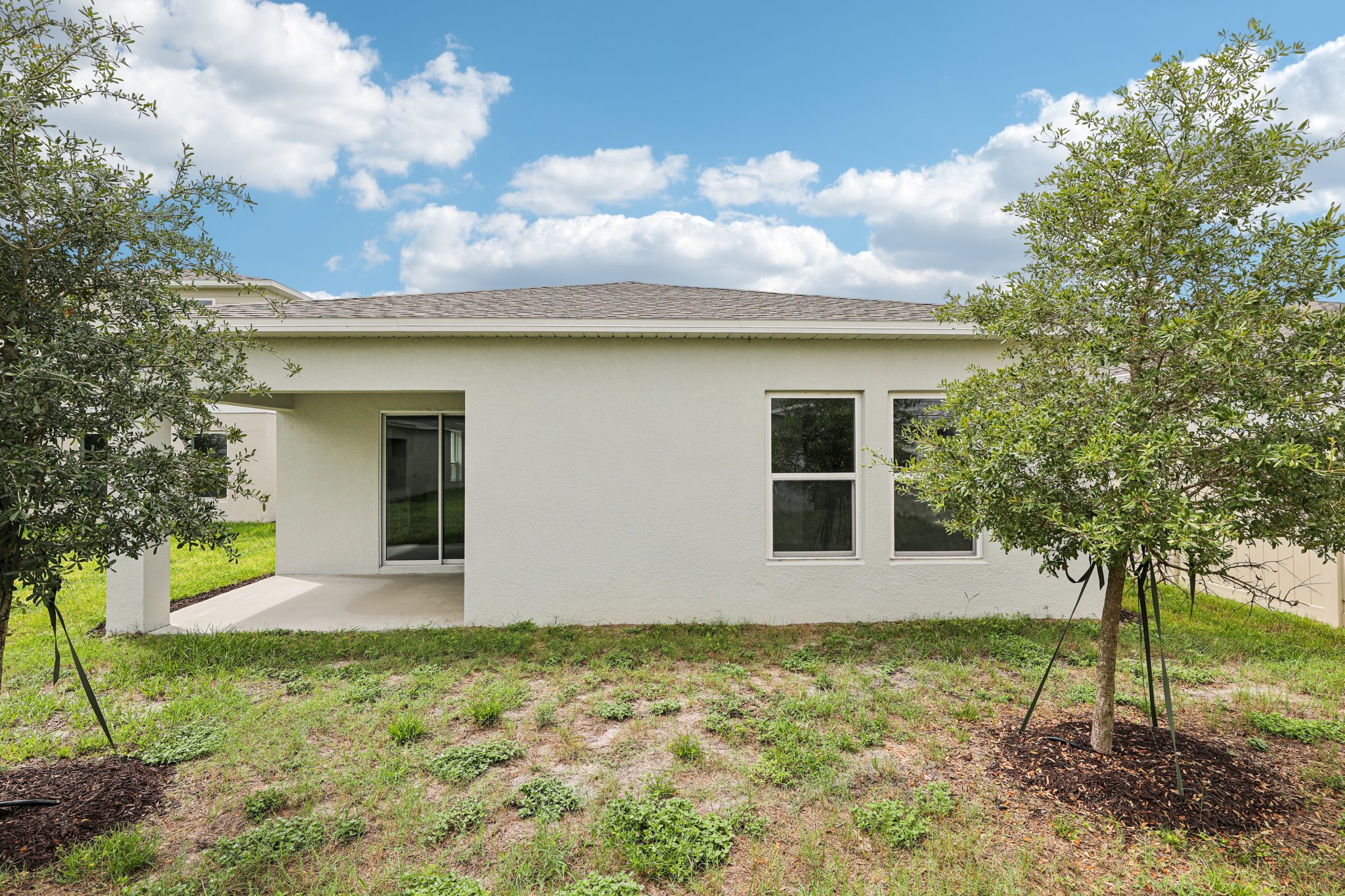 A white house with trees in front.