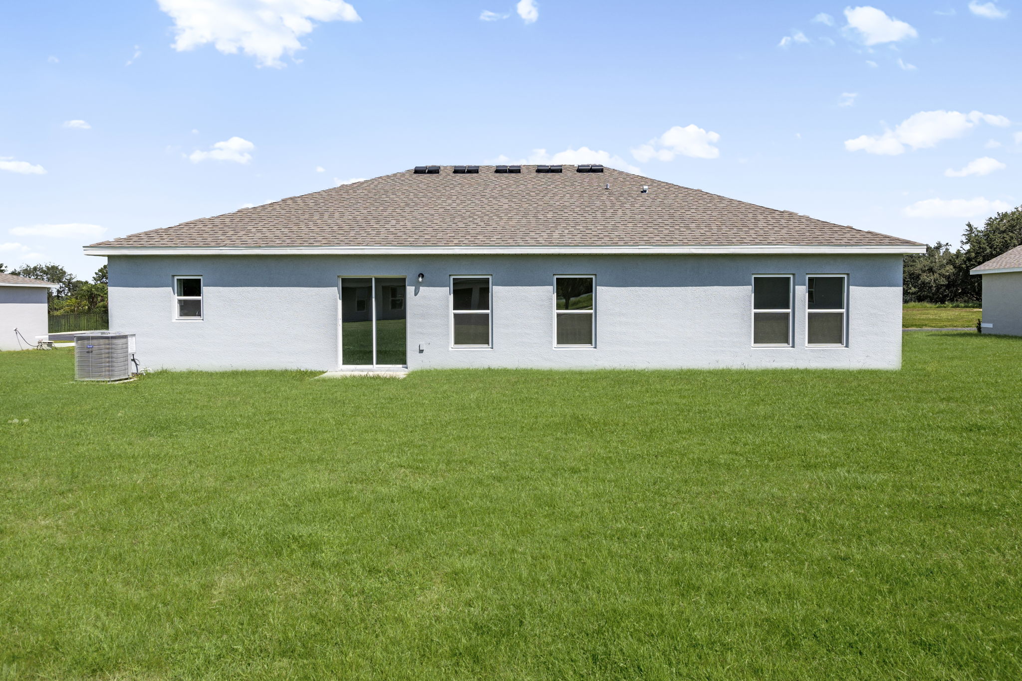 A white house with a grass yard.