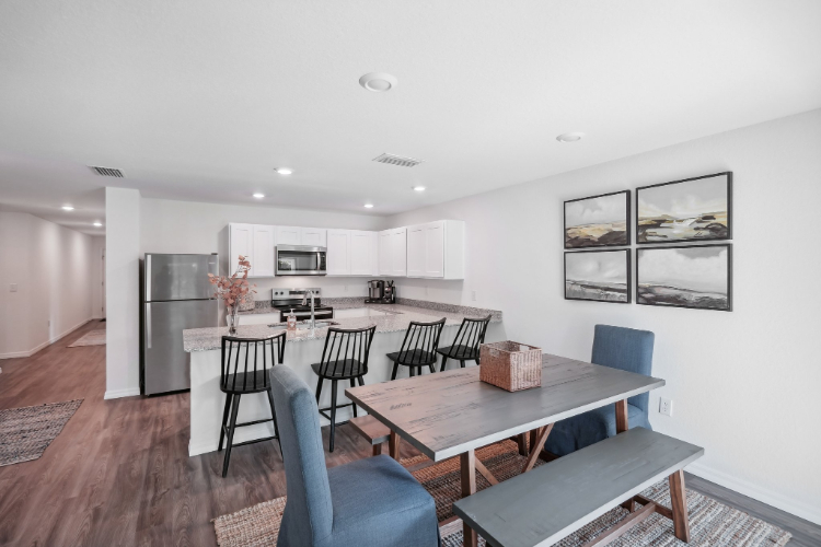 A kitchen with a dining table and chairs.
