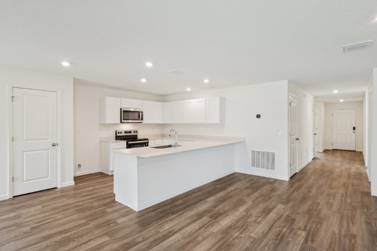 A kitchen with white cabinets.