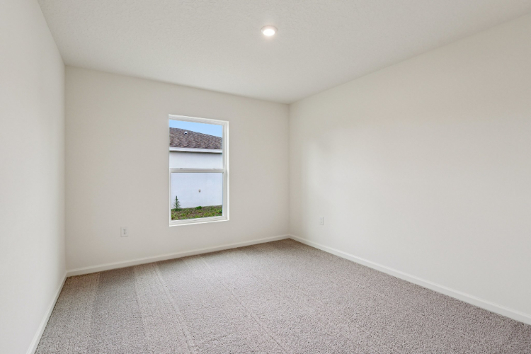 A room with a window and a carpet.