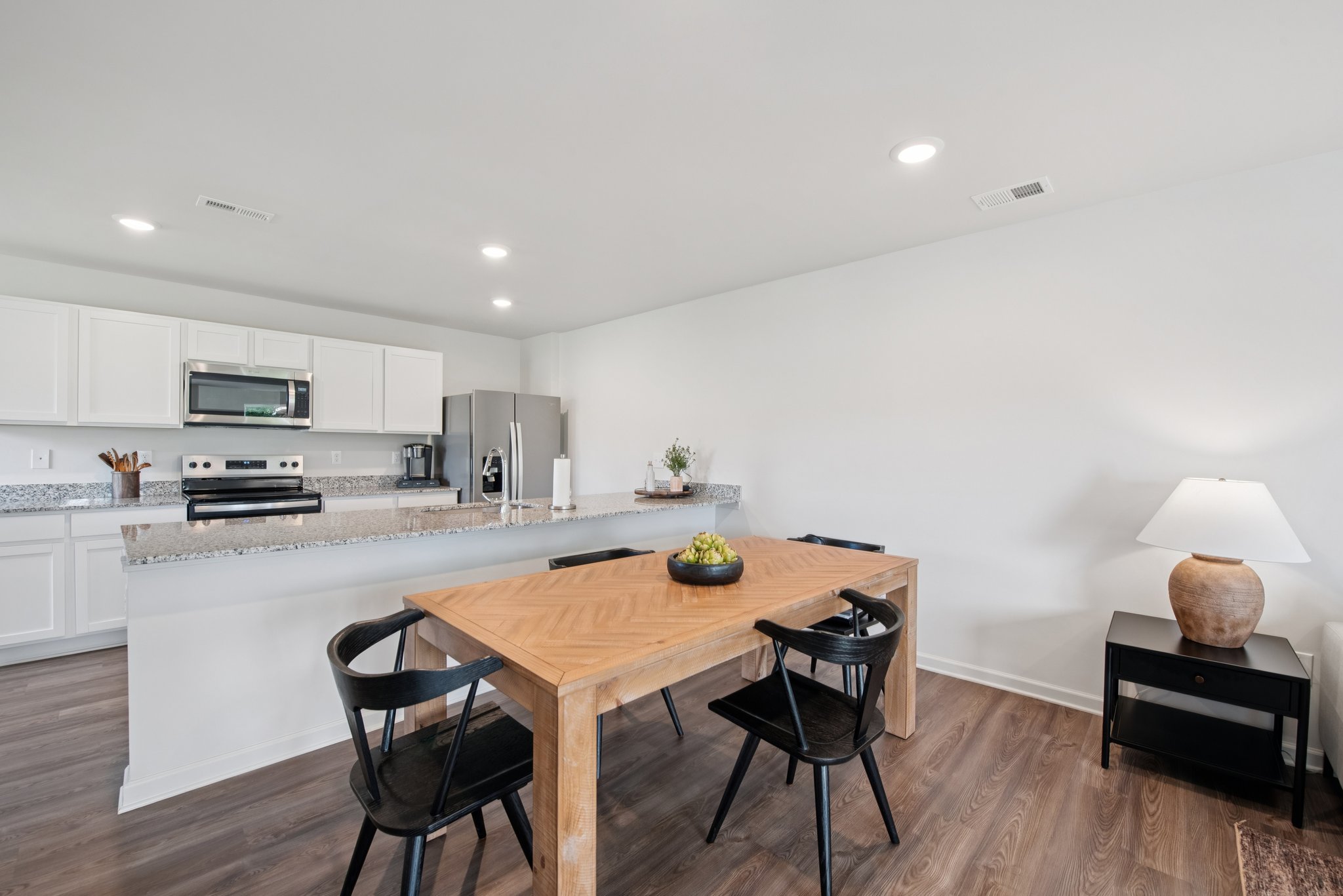 A kitchen with a table and chairs.