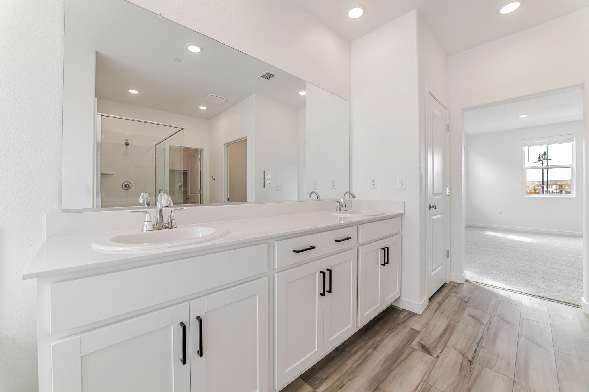 A bathroom with white cabinets.