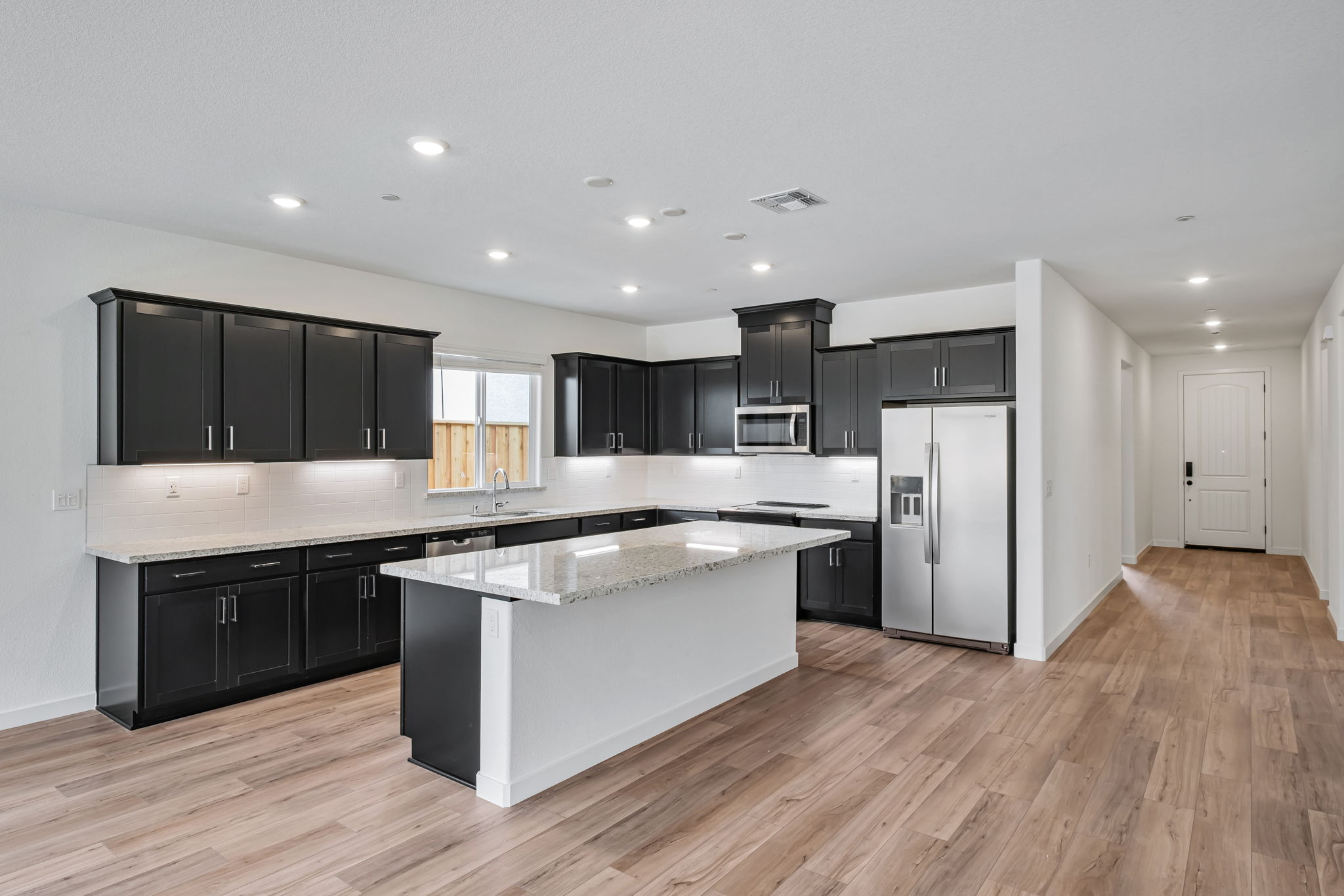 A kitchen with black cabinets.