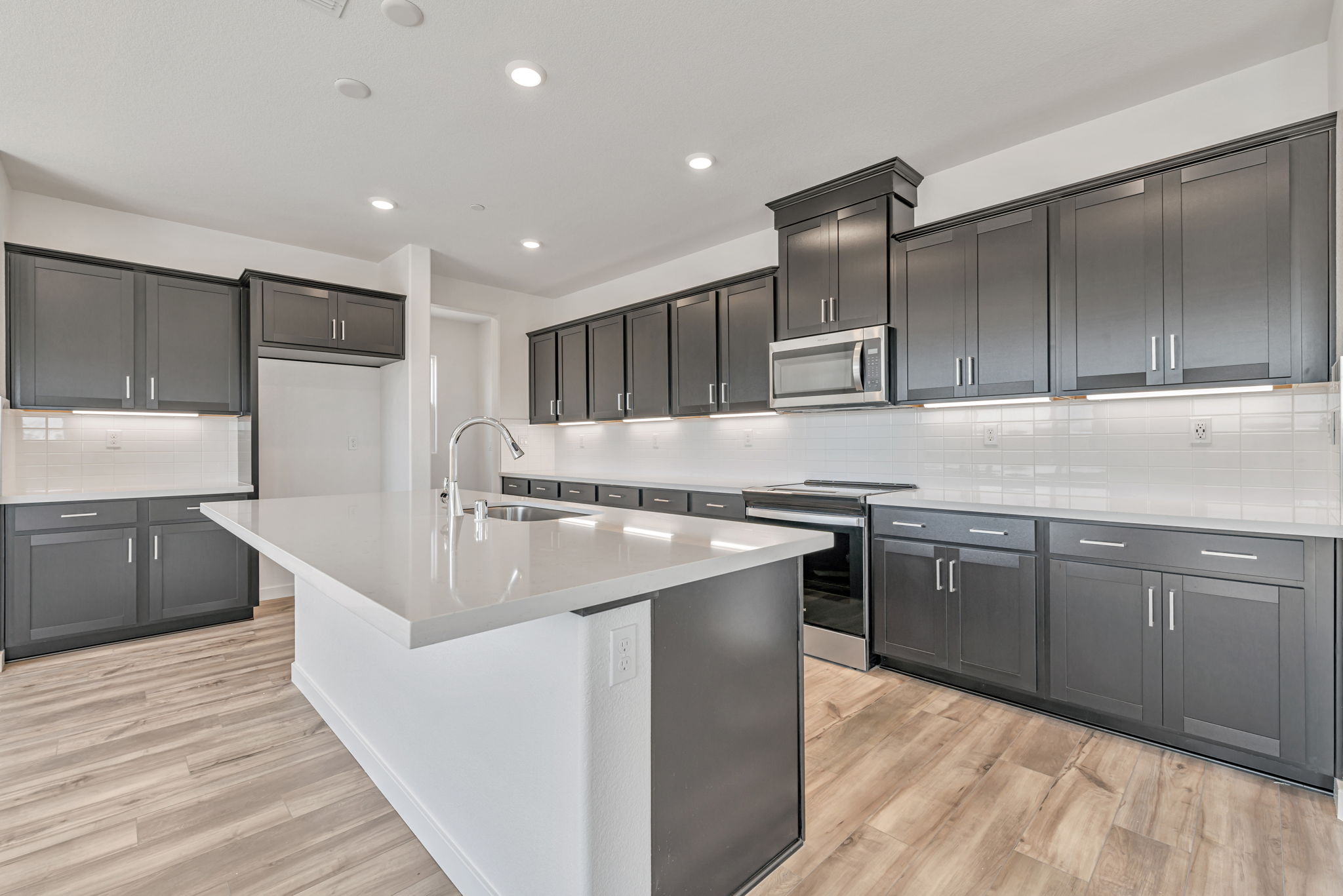 A kitchen with black cabinets.