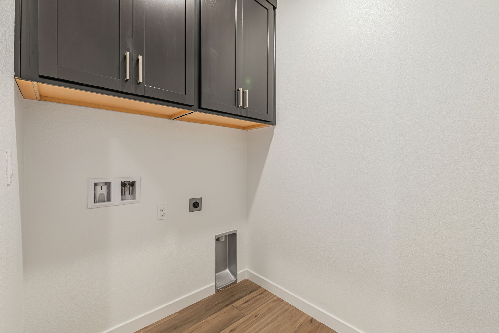 A room with a wood floor and cabinets.